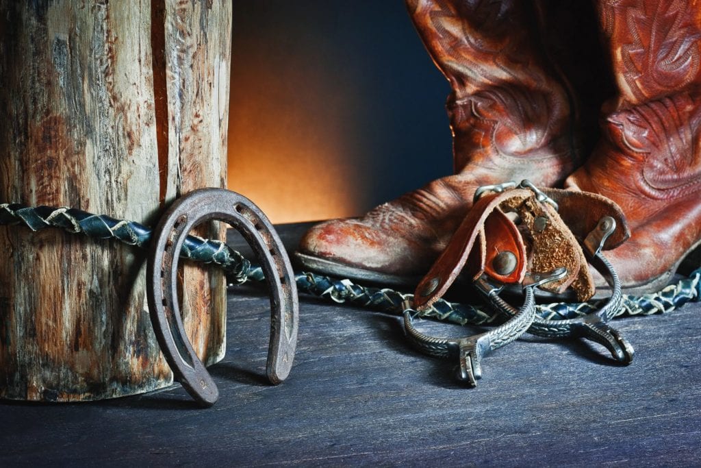 Cowboy boots beside a horseshoe